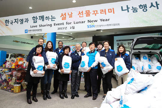 한국GM 한마음재단은 12일 한국GM 부평본사 홍보관에서 독거노인과 소외가정에 직접 만든 생필품 선물꾸러미 500세트를 전달했다. 사진은 세르지오 호샤 한국GM 사장(앞줄 중앙 왼쪽)과 한창원 인천사회복지협의회장(앞줄 중앙 오른쪽)을 비롯해 이번 행사에 참석한 한국GM 임직원 및 수혜기관 대표자들이 다함께 선물 꾸러미를 들고 웃고 있는 모습. <한국GM 제공>
